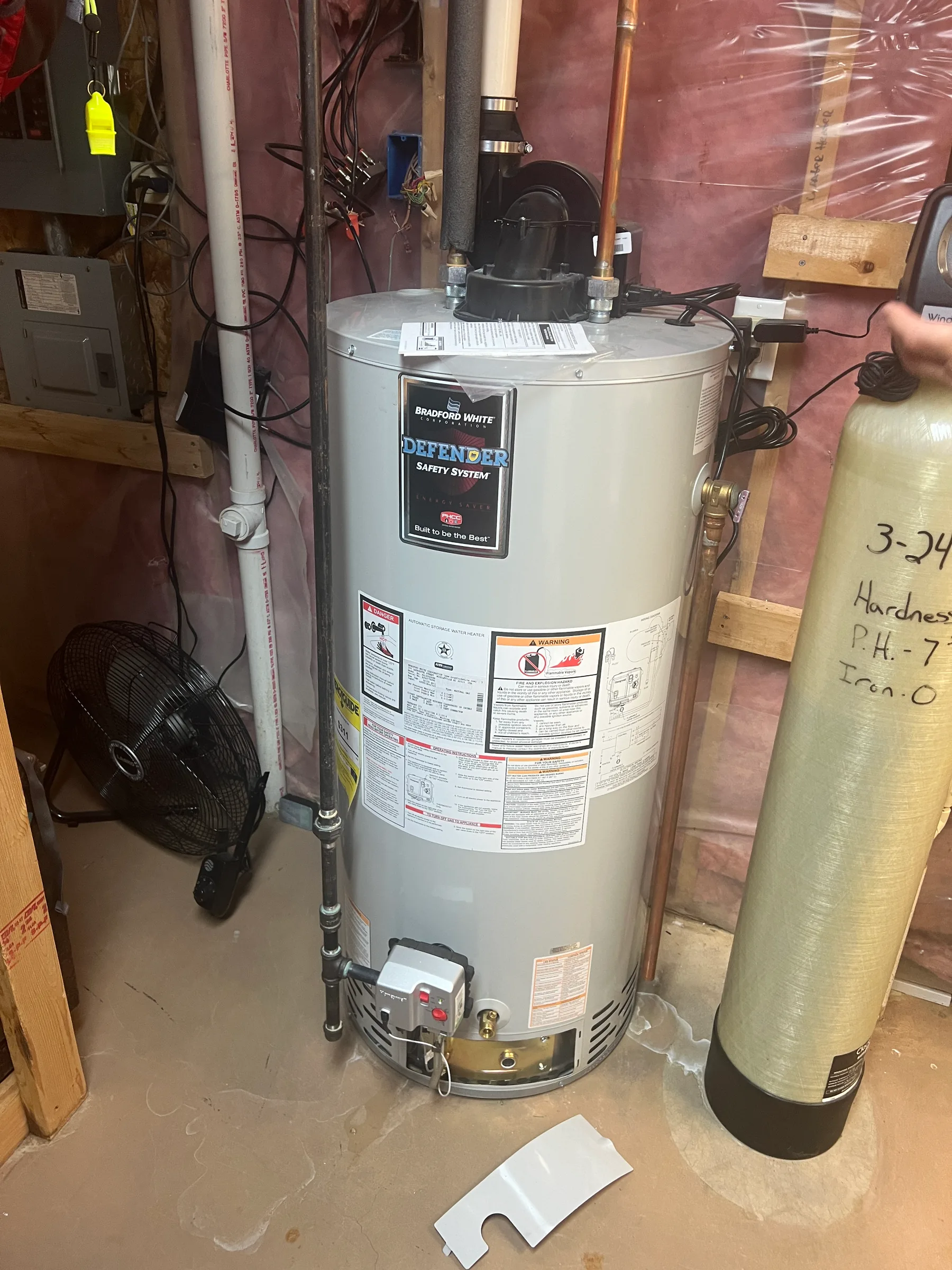 Bradford White Defender water heater with safety system installed in a basement utility room.